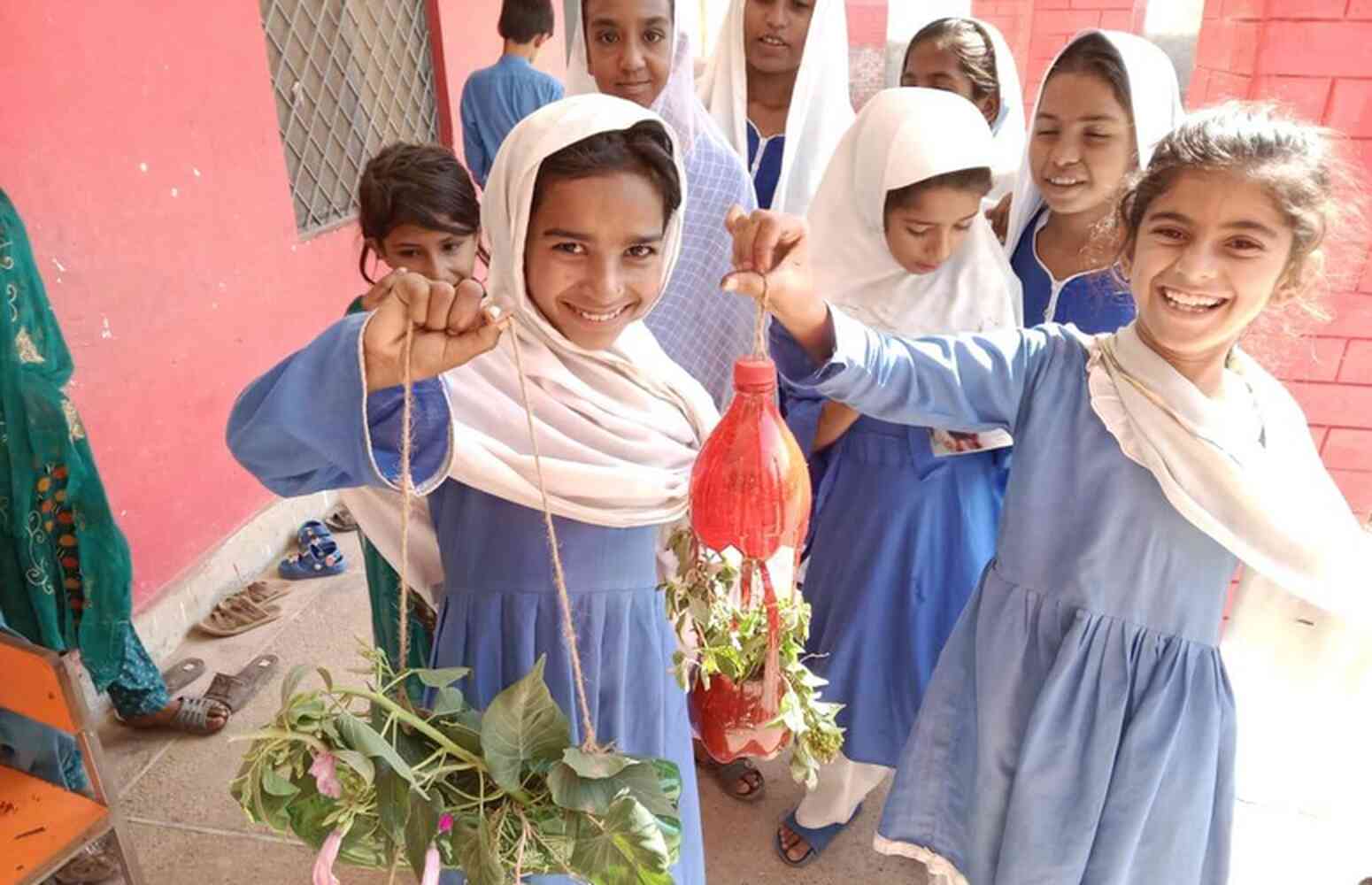 Climate Change Education - Girls holding plants A group of female school children holding up plants.